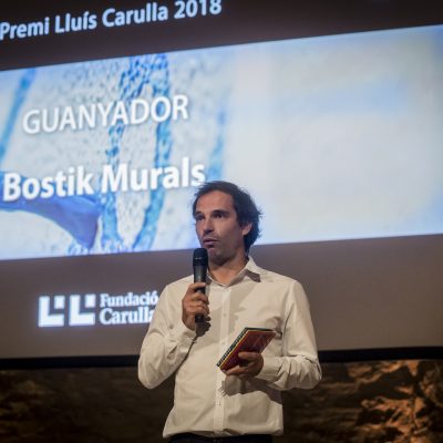 Xavier Ballaz de B-Murals parlant a l'escenari durant el lliurament del Premi Lluís Carulla 2018.
